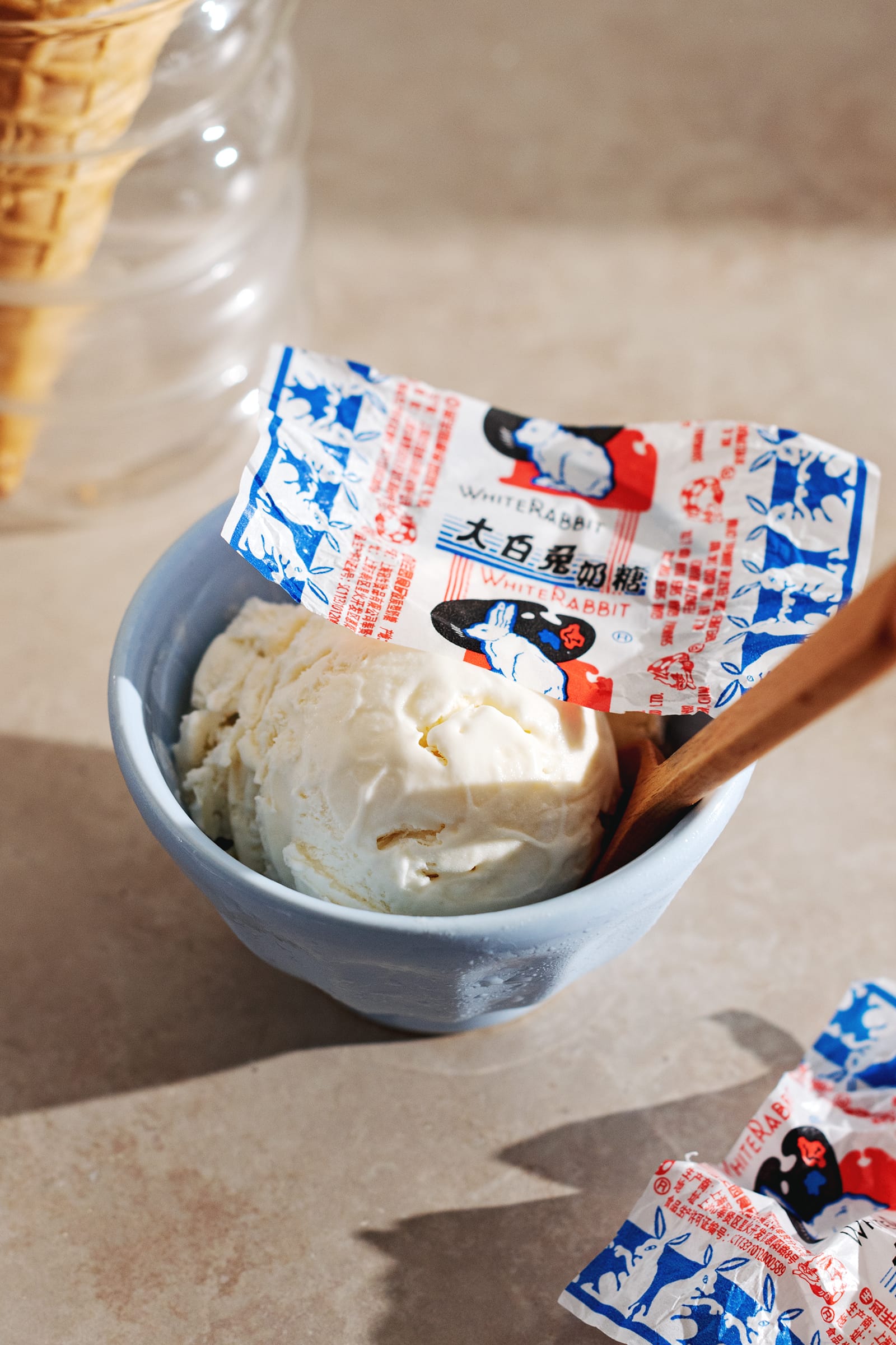 Blue bowl with a scoop of ice cream in it and white rabbit candy wrapper on top.