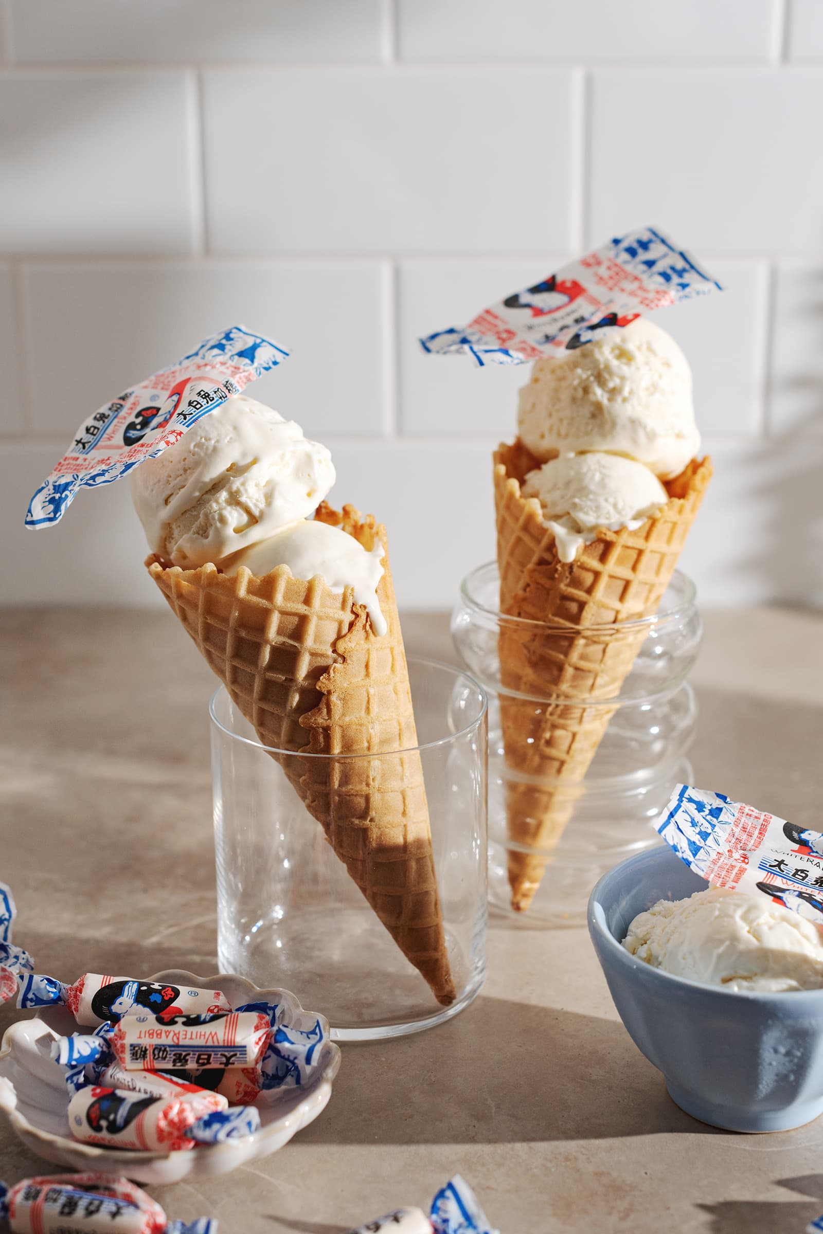 Two white rabbit ice cream cones standing up in glasses.