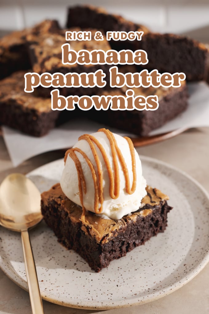 A brownie square topped with a scoop of vanilla ice cream and drizzled with peanut butter on a plate.