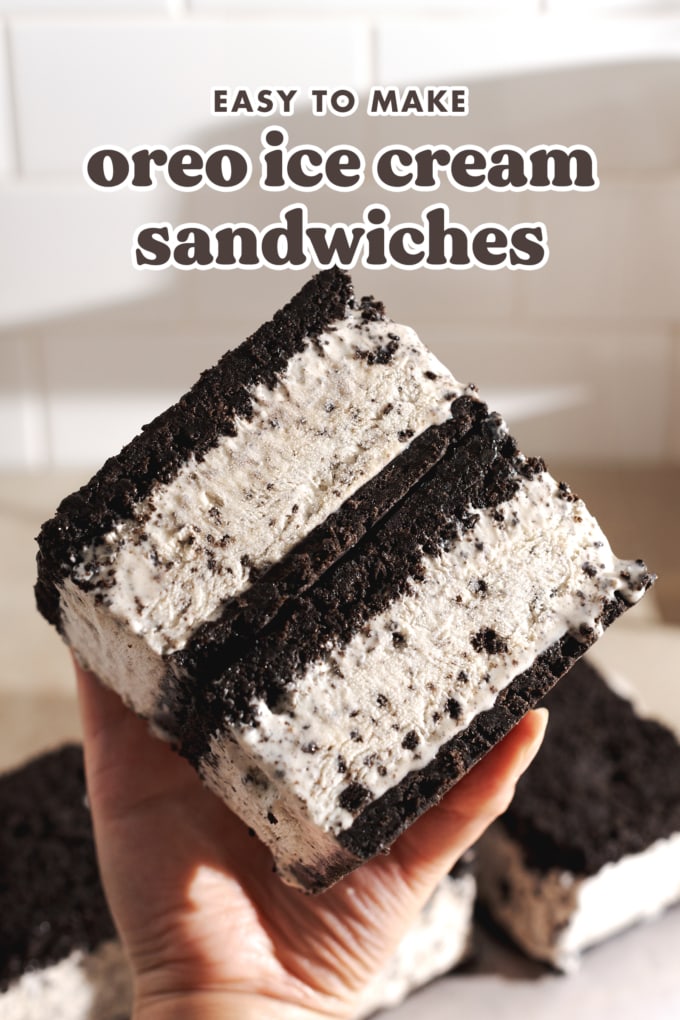 Hand holding a stack of two oreo ice cream sandwiches to show the layers.