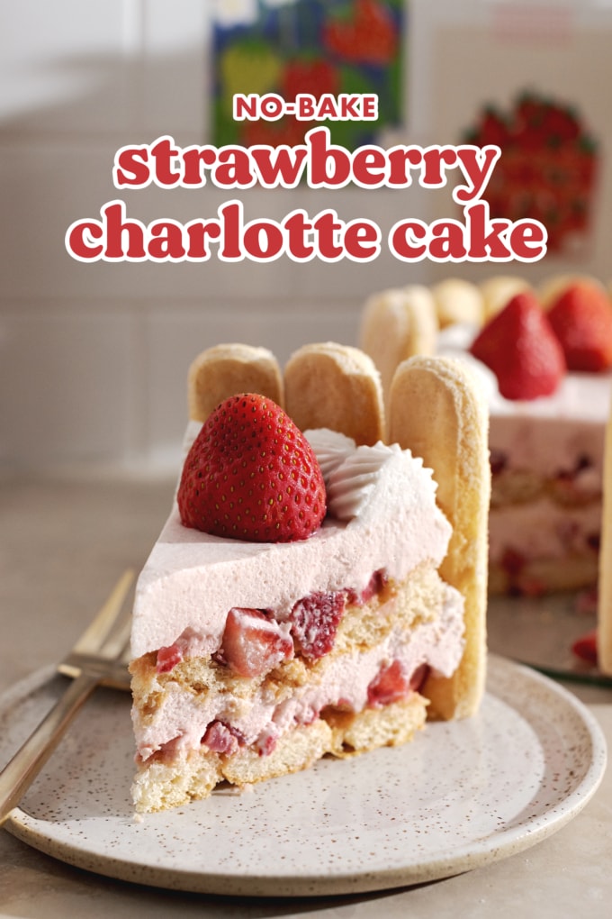 A slice of strawberry charlotte cake on a plate showing the layers and whole strawberry on top.