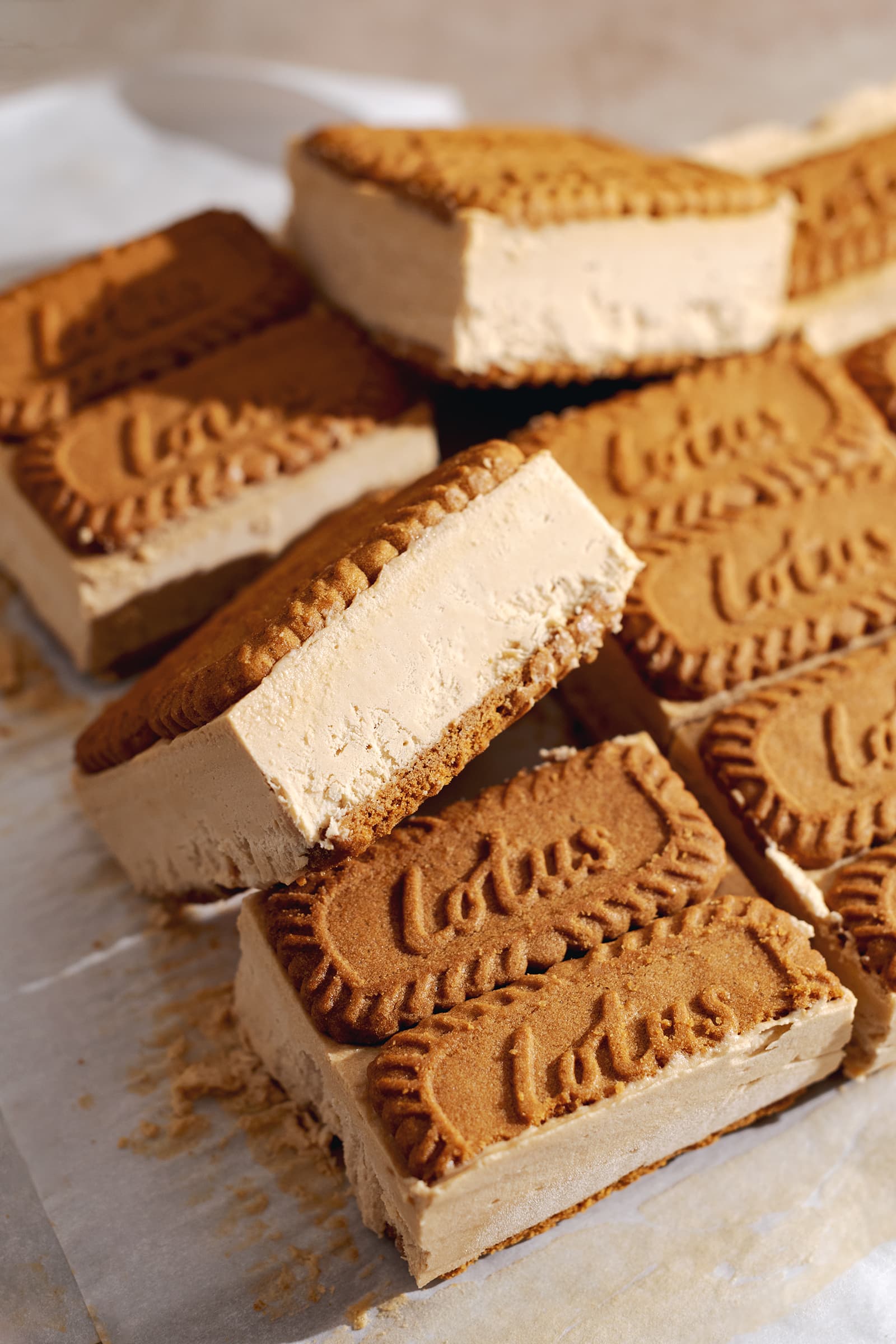 Biscoff ice cream sandwich tilted on its side resting on other sandwiches.