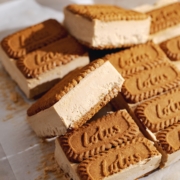 Biscoff ice cream sandwich tilted on its side resting on other sandwiches.