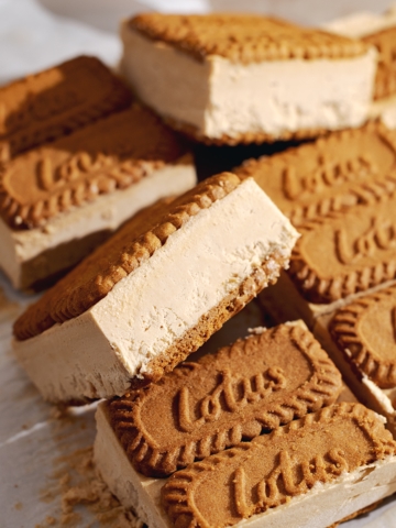 Biscoff ice cream sandwich tilted on its side resting on other sandwiches.