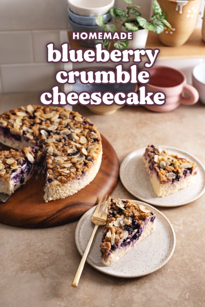 Slices of cheesecake with crumble topping on plates and the whole cheesecake on a wooden platter.