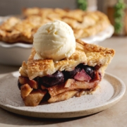 Side view of a slice of pie with scoop of ice cream on top.