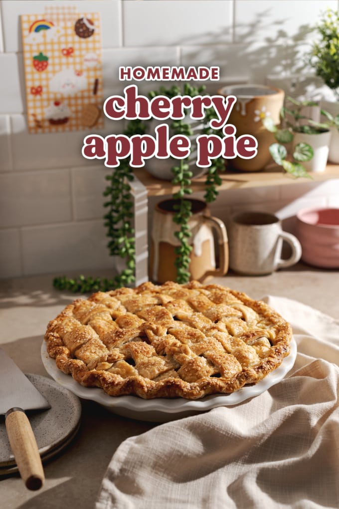 A baked pie on a kitchen counter in front of a shelf of mugs and plants.