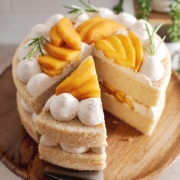 A slice of peach cake cut from the rest of the cake resting on a cake server.