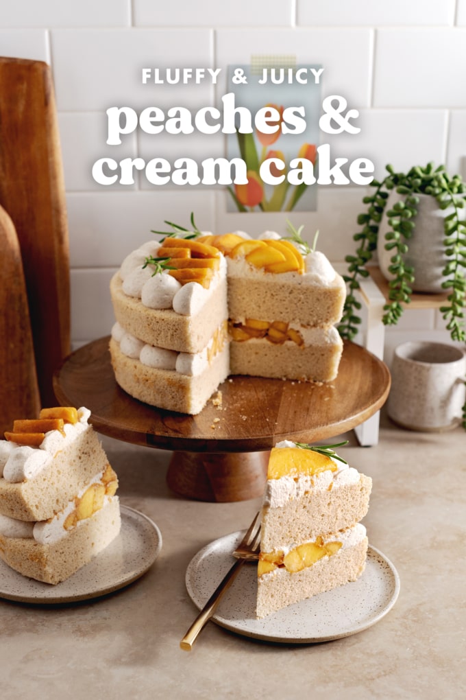 Two slices of peaches and cream cake on plates with the rest of the cake on a wooden cake stand behind them.