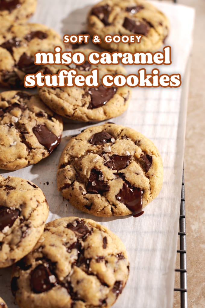 Miso caramel cookies with melty chocolate chunks scattered on a wire rack.