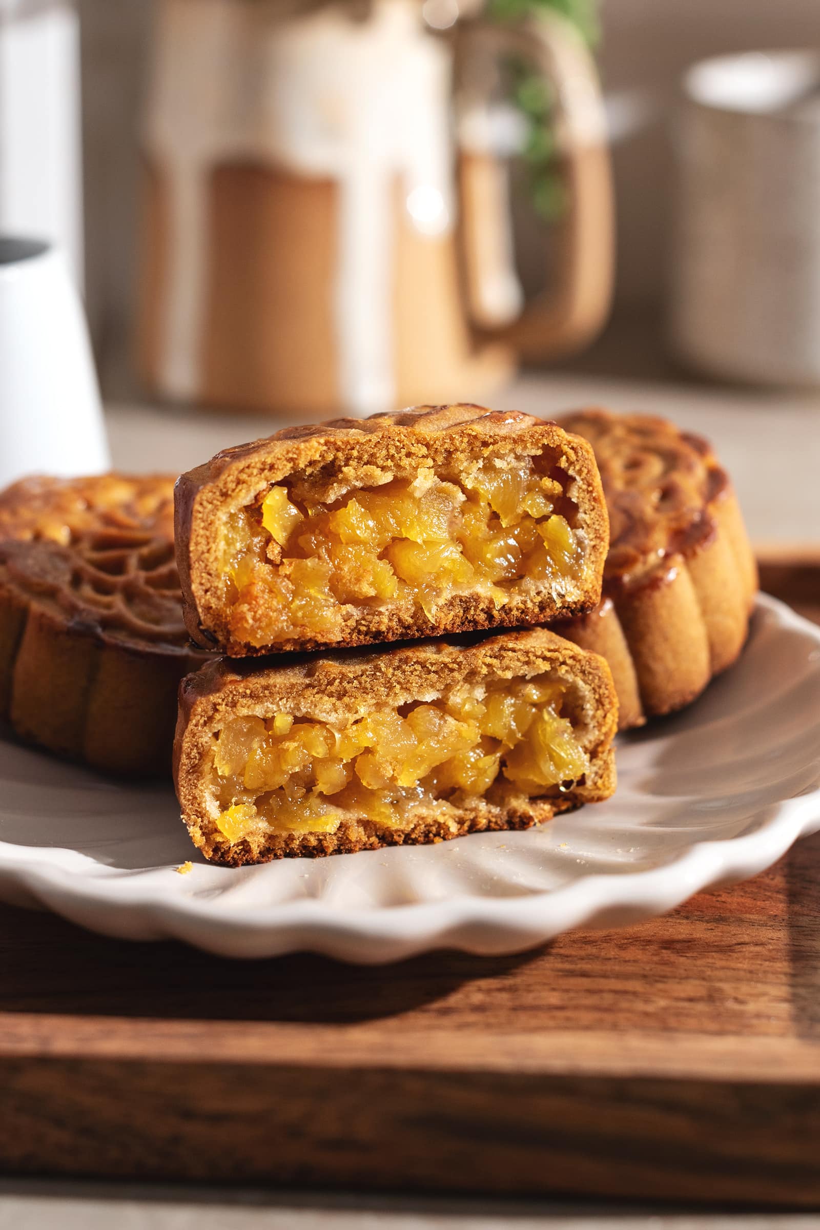 Pineapple mooncake cut in half with both halves stacked on top of each other to show pineapple filling inside.