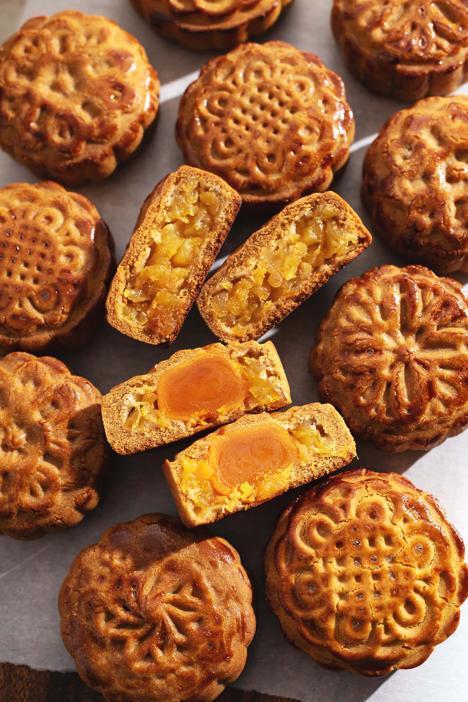Mooncakes cut in half to show pineapple and salted egg yolk filings.