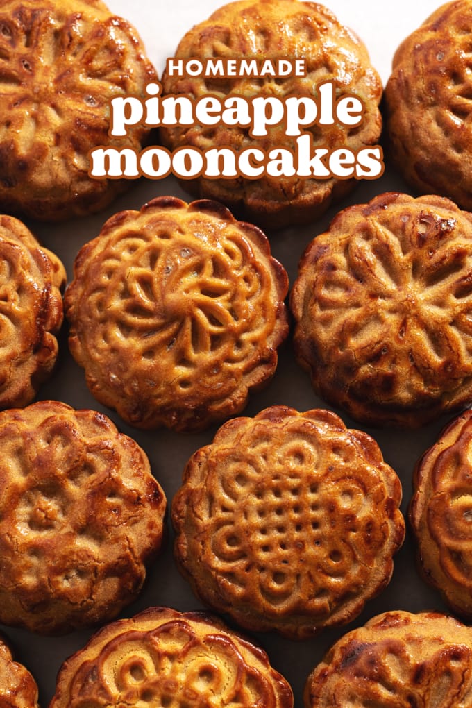 Several baked mooncakes with different designs lined up across the frame.