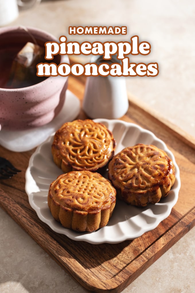 Three mooncakes on a plate on a tray with a cup of tea.