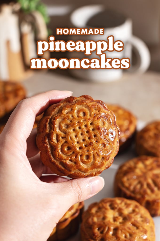 Hand holding a baked mooncake to show shine on the top.