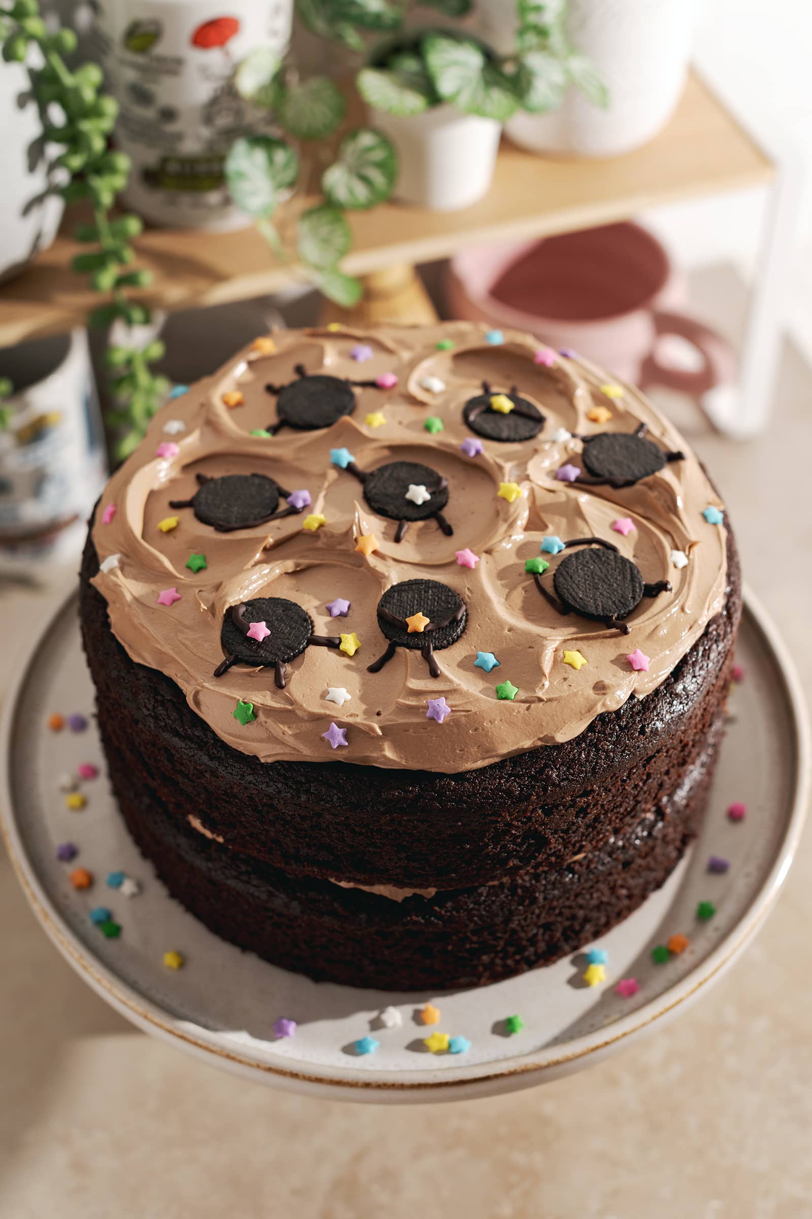 Mini oreo soot sprites with star sprinkles on top of a chocolate cake.