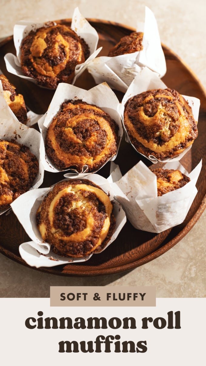 Several cinnamon roll muffins on a wooden platter.