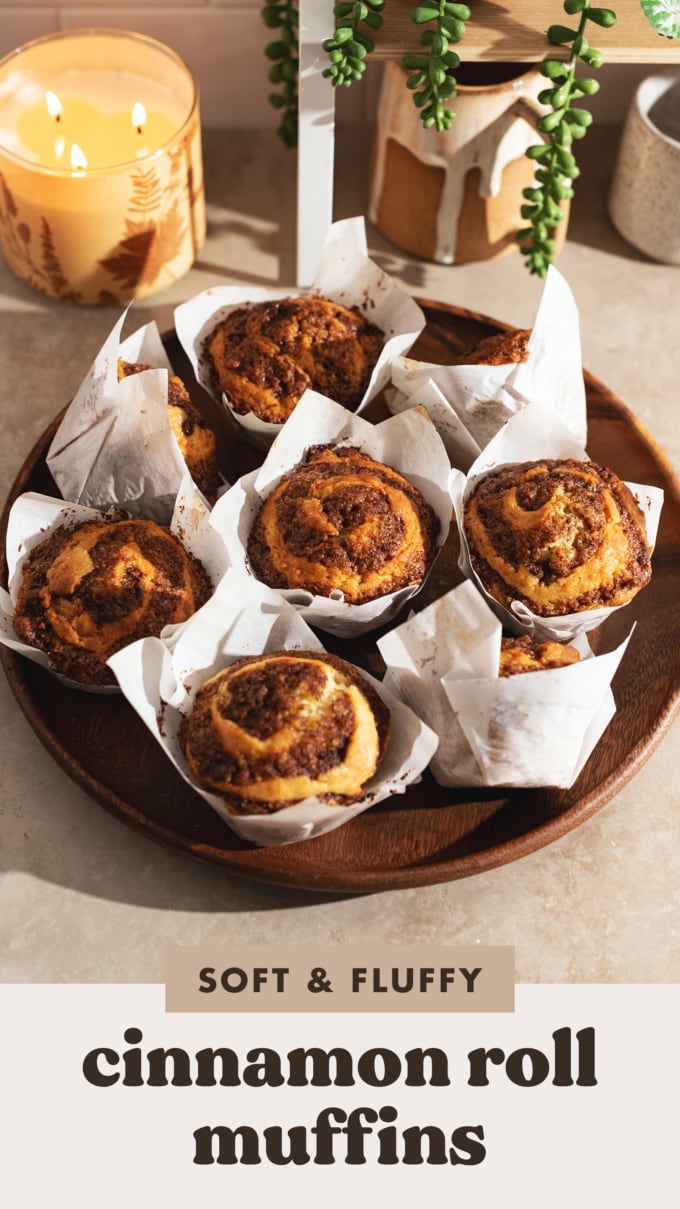 Cinnamon roll muffins in muffin liners on a wooden platter.