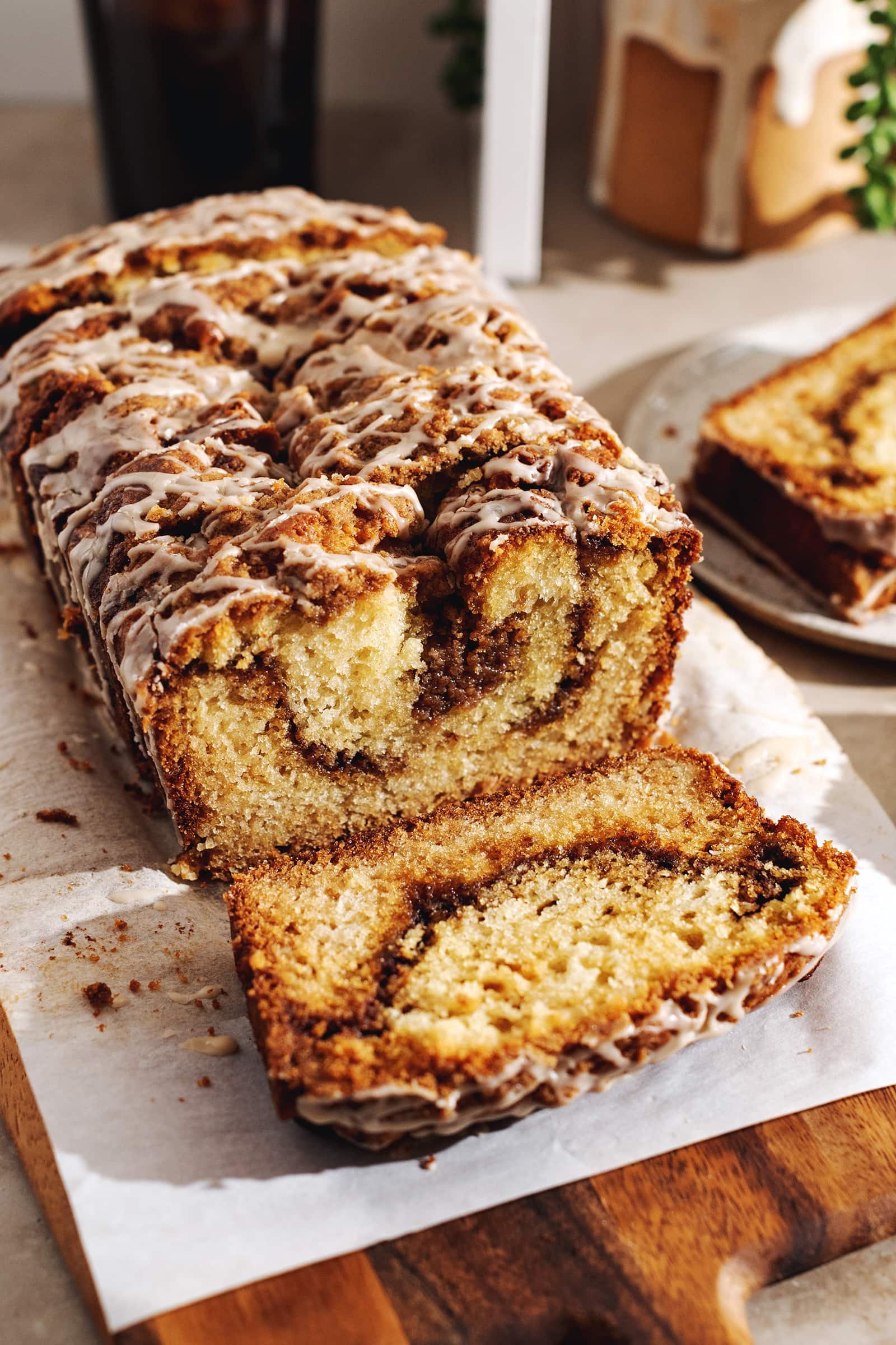 A loaf of cinnamon streusel bread with a slice cut off laying in front of it.
