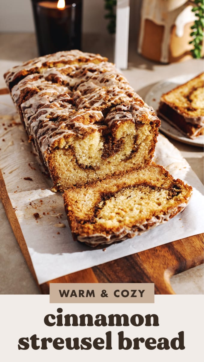 A loaf of cinnamon streusel bread with a slice cut off laying in front of it.