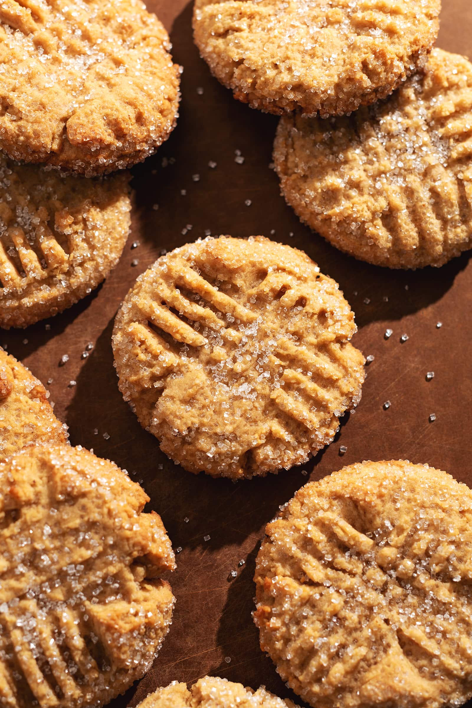 Overhead view of peanut butter miso cookies scattered on a wooden board.