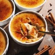 A spoon resting in a ramekin of cracked pumpkin crème brûlée.
