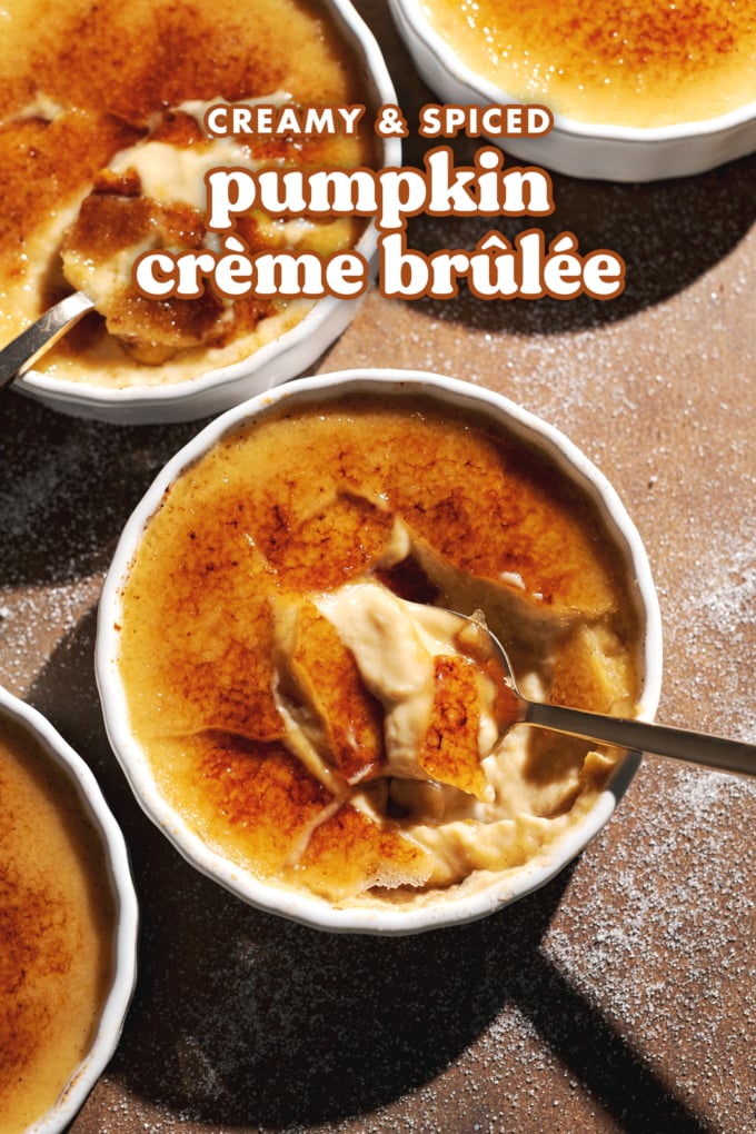 Ramekins of crème brûlée cracked with spoons to show the custard inside.