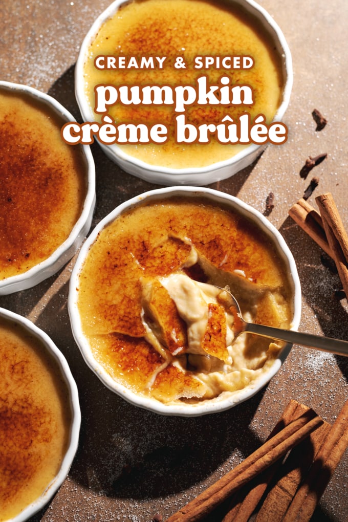 A spoon resting in a ramekin of cracked pumpkin crème brûlée with cinnamon sticks around it.