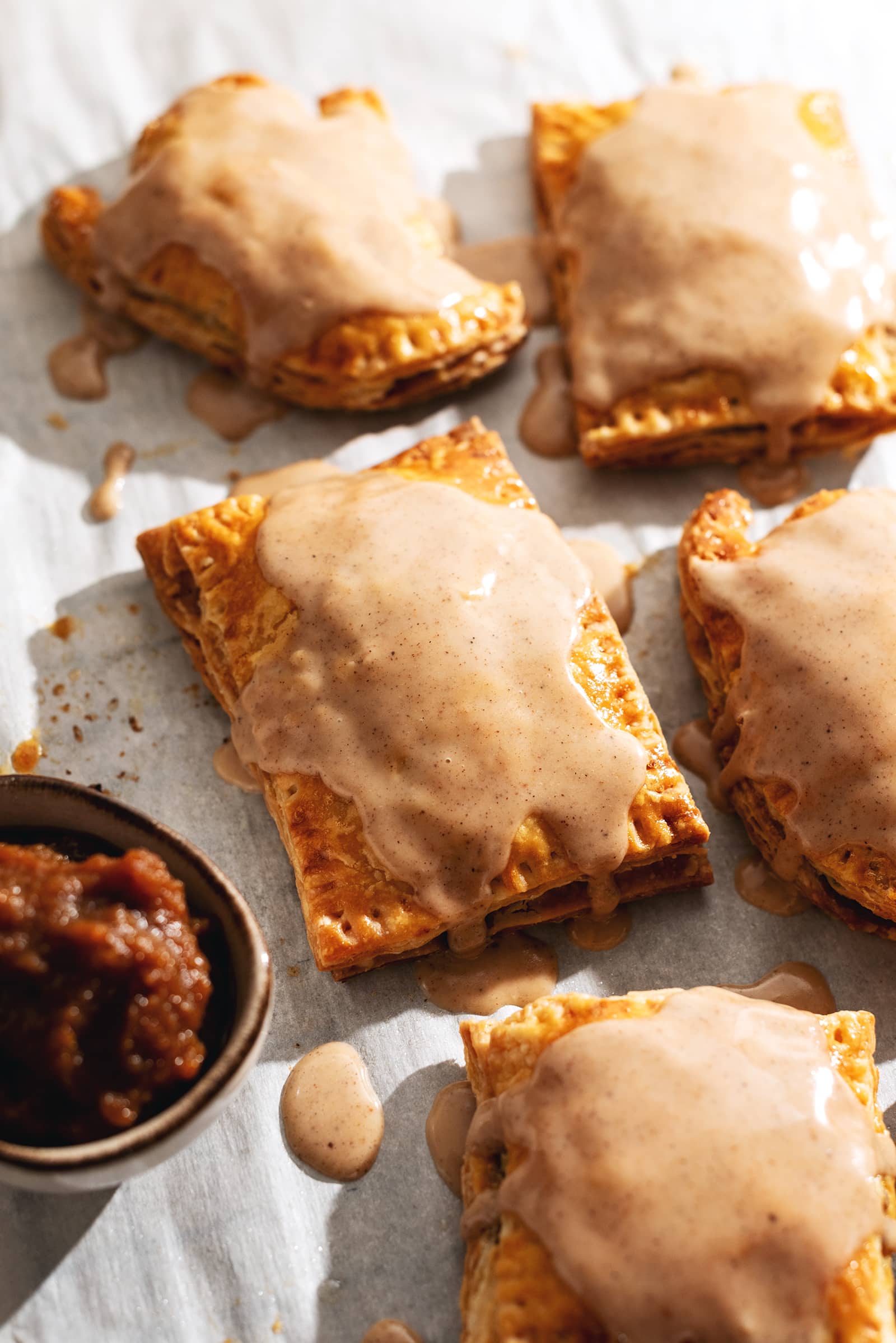 Pumpkin pop tarts with icing dripping down the sides.
