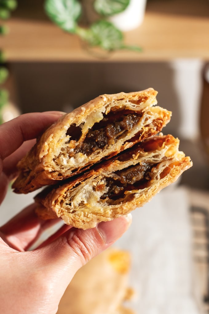Hand holding a pop tart cut in half to show the pumpkin filling inside.