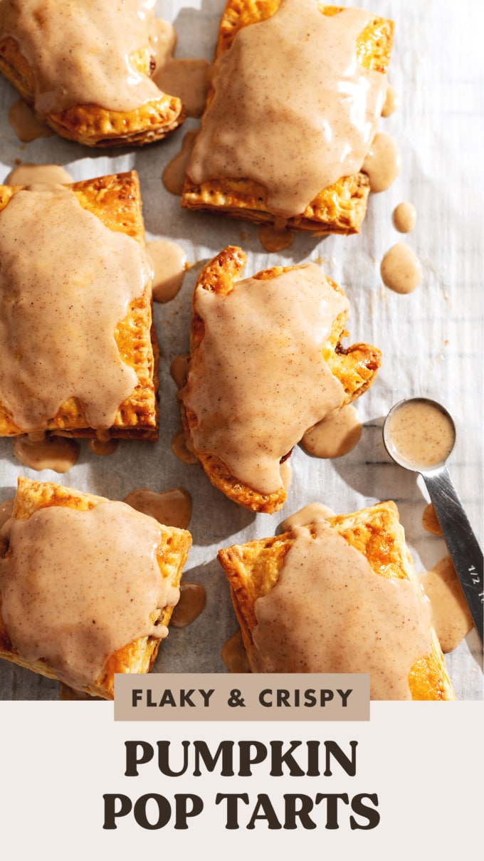Pumpkin pop tarts in rectangle and ghost shapes on parchment paper with a spoon of icing.