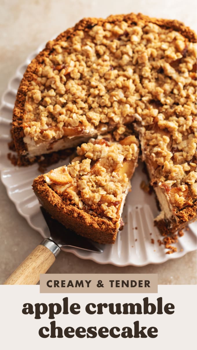 A slice of apple crumble cheesecake cut from the rest of the cake on a cake server.