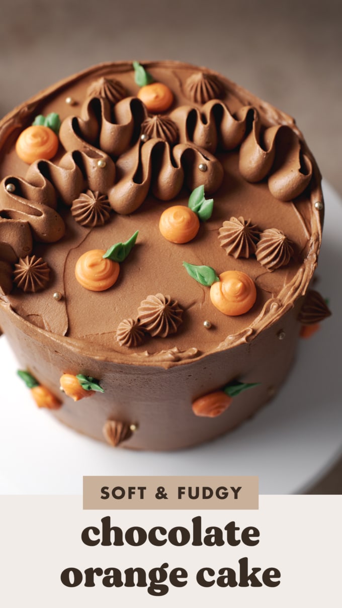 Cake decorated with squiggles of chocolate buttercream and little piped oranges.