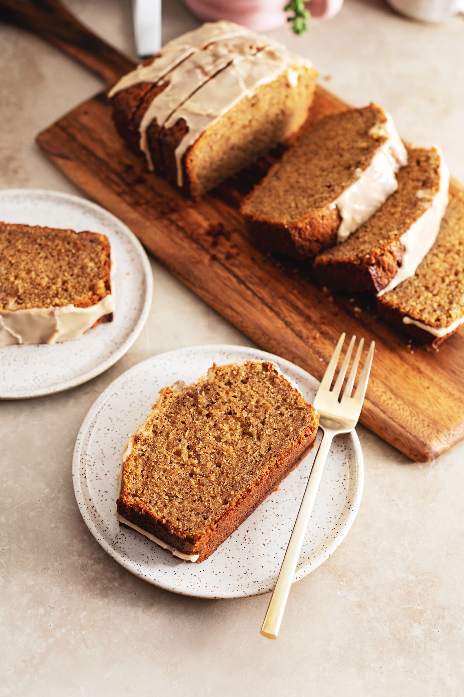 Slices of pound cake on plates in front of a wooden board with the rest of the slices.