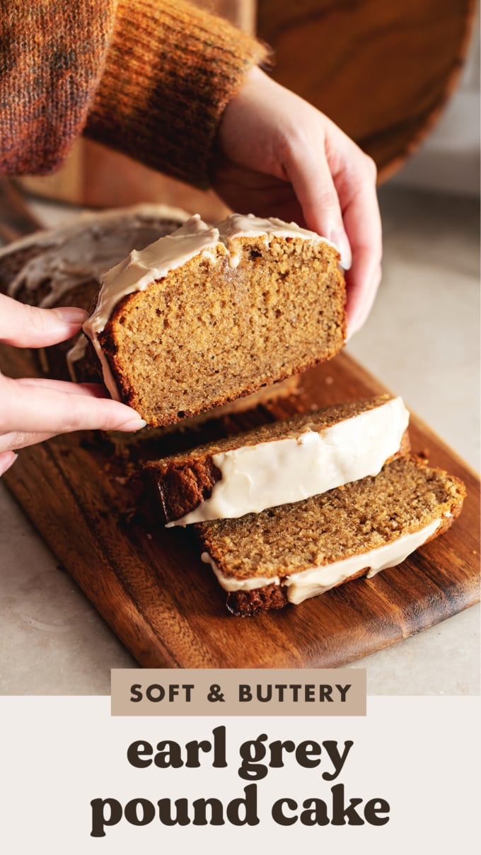 Hands holding a slice of earl grey pound cake above the rest of the loaf.