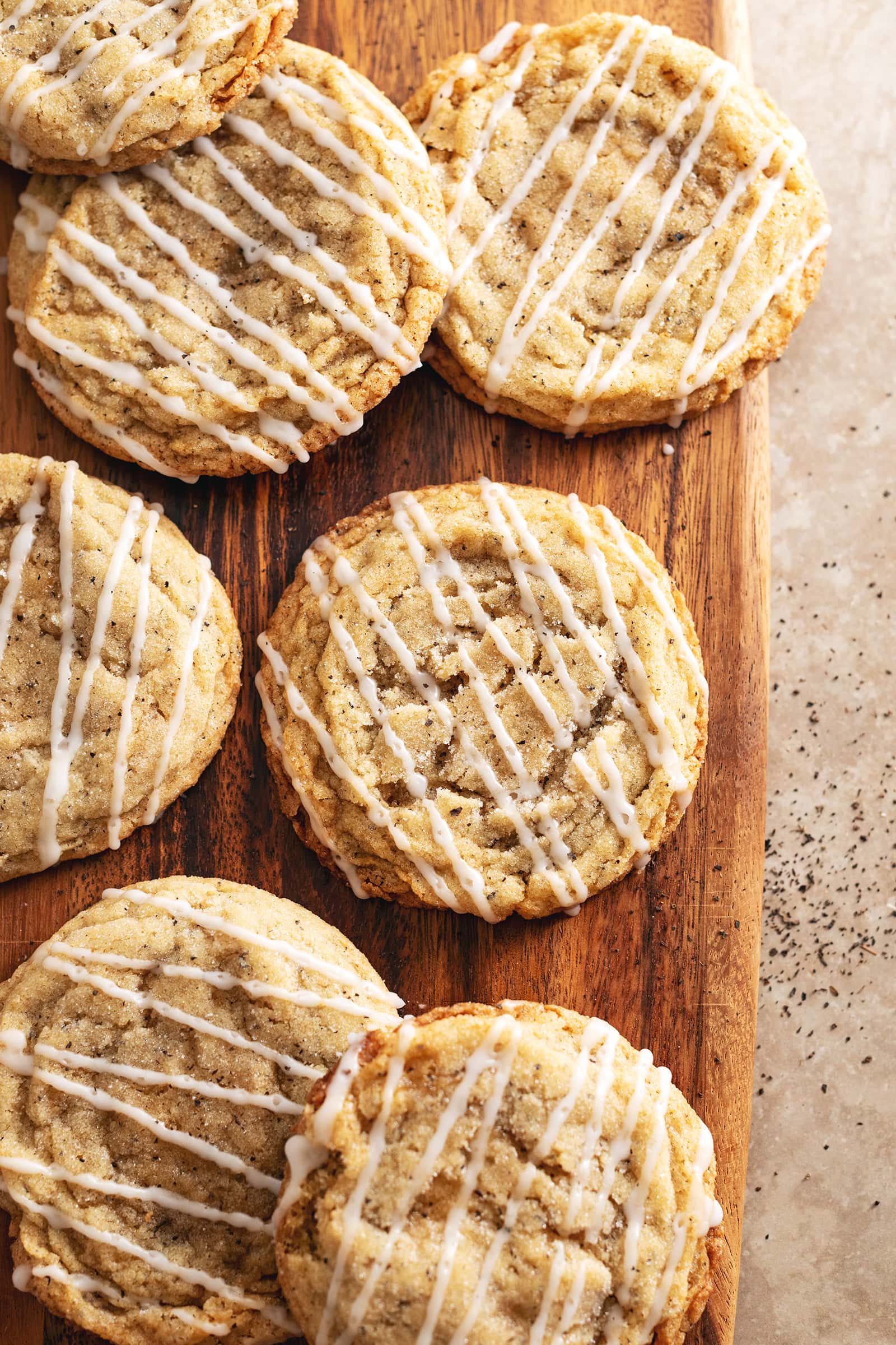 Earl grey sugar cookies scattered on a wooden board.