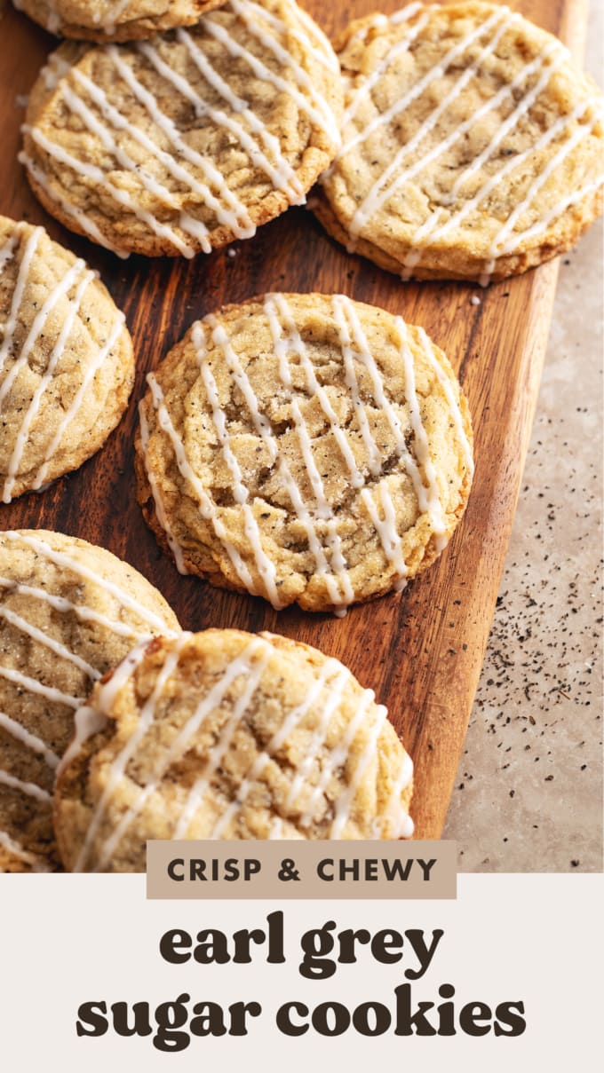 Earl grey sugar cookies drizzled with glaze scattered on a wooden board.