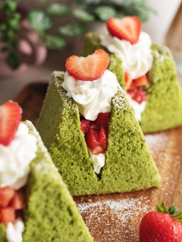Close-up of a matcha chiffon cake sandwich filled with whipped cream and strawberries.