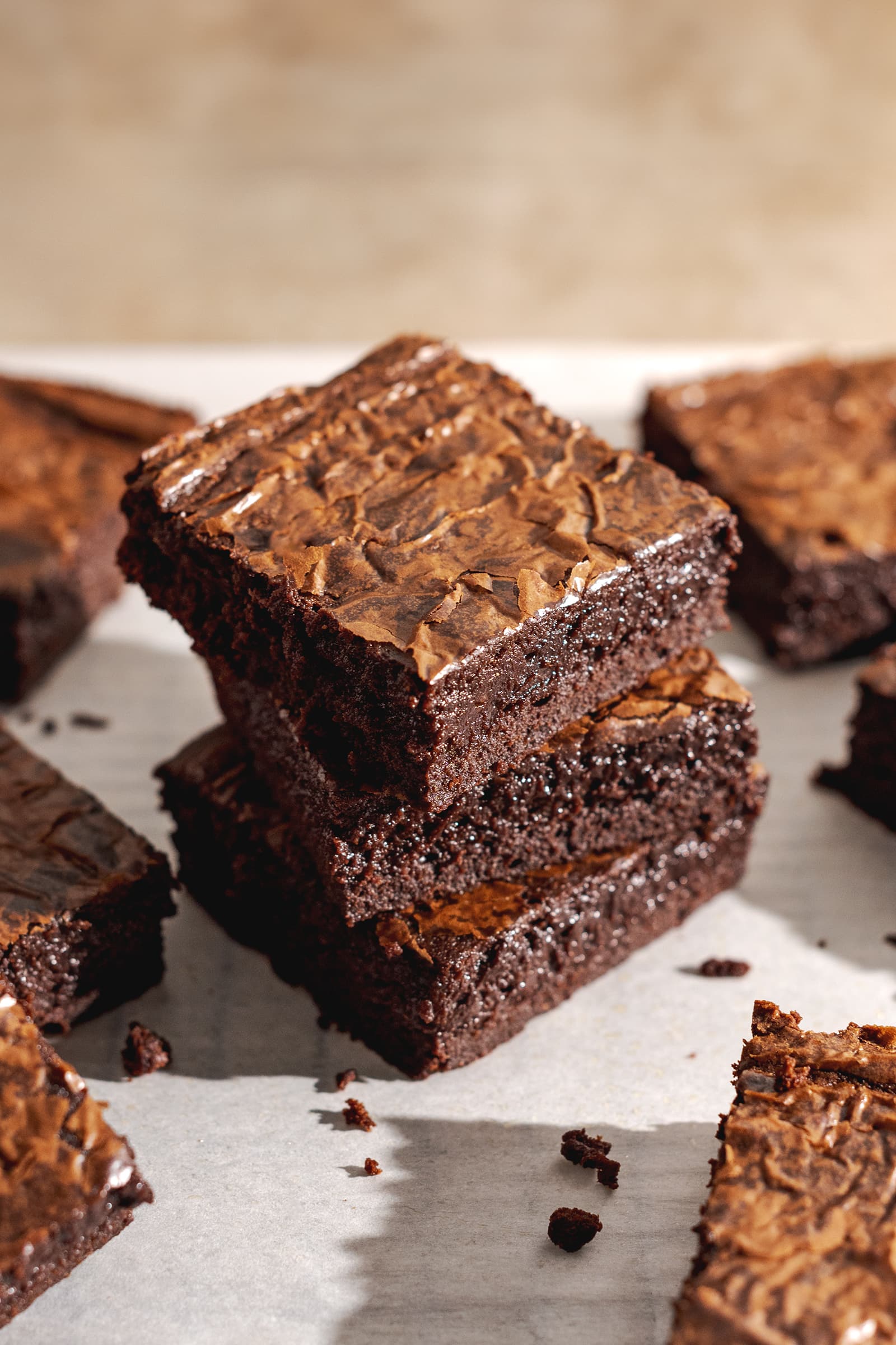 A stack of three miso brownies on parchment paper.
