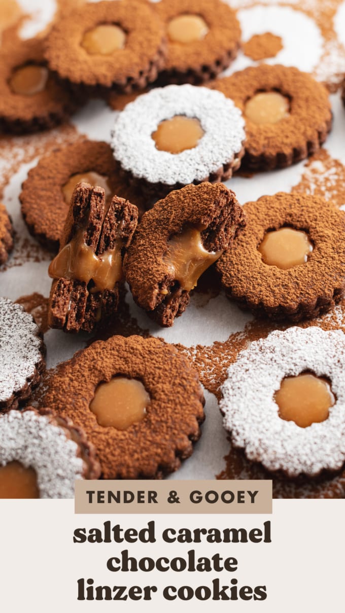 Two salted caramel chocolate linzer cookies split in half to show the gooey caramel filling inside.