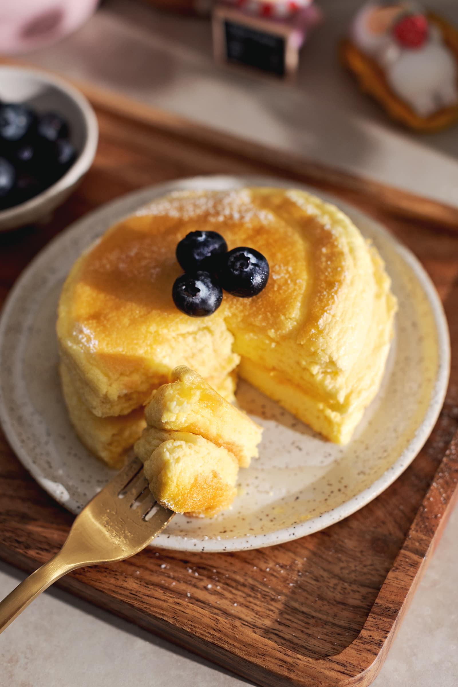 A forkful of Japanese souffle pancake sitting in front of the rest of the pancakes.