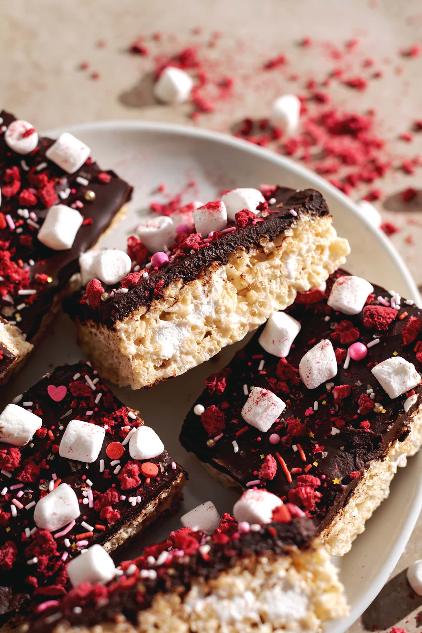 A Valentine's Day rice krispie treat leaning on its side to show the layers of chocolate ganache and rice krispies.