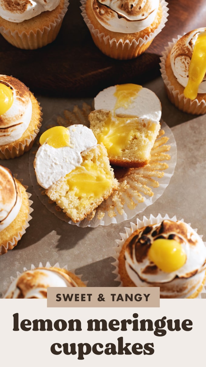 A lemon meringue cupcake cut in half to show the lemon curd filling inside.