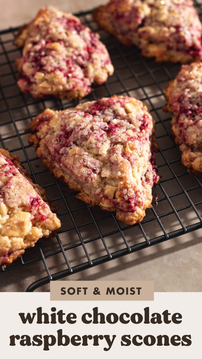 White chocolate raspberry scones lined up on a wire rack.