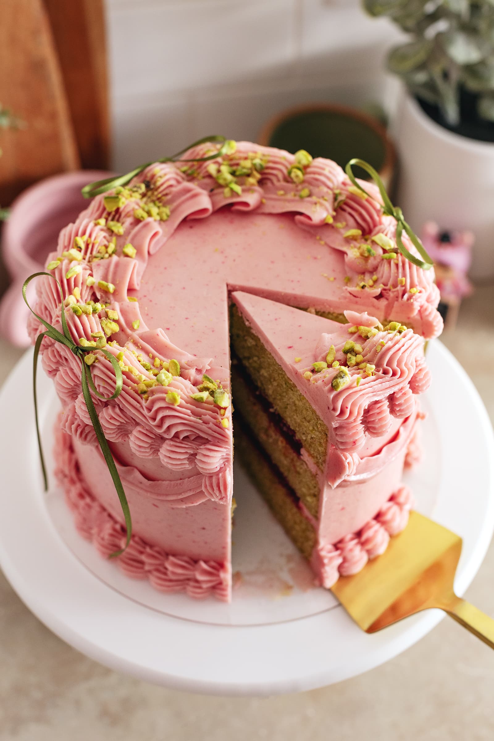 A slice of raspberry pistachio cake cut from the cake.