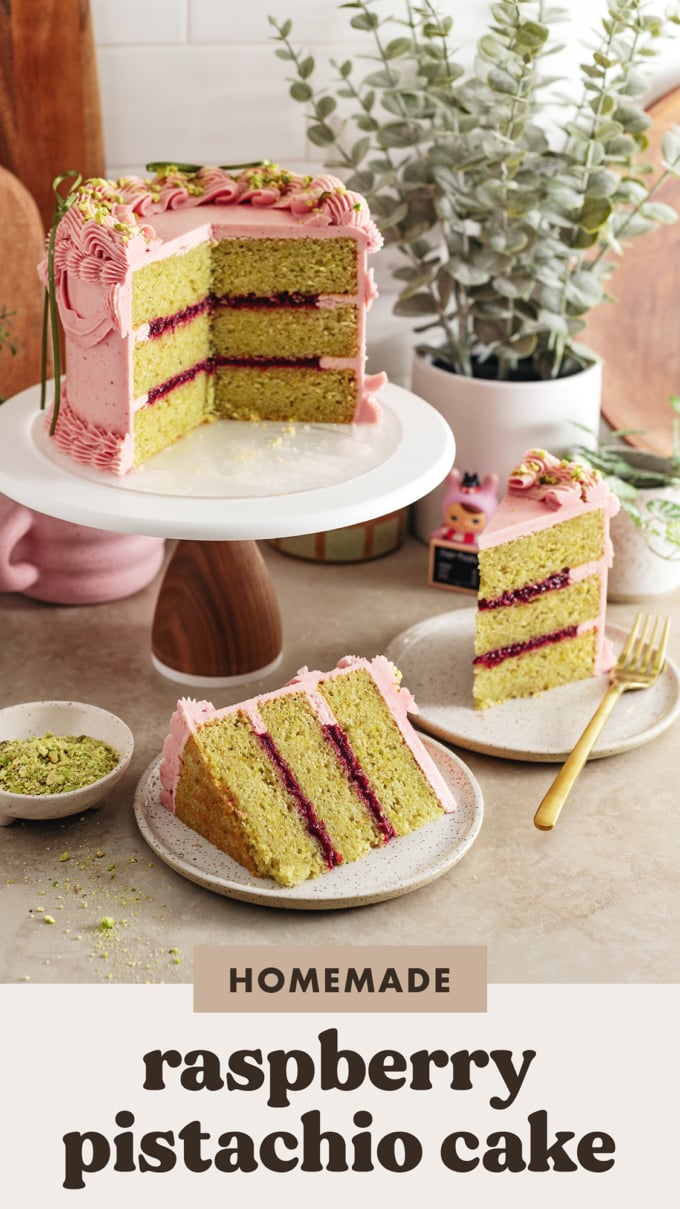 A raspberry pistachio cake on a cake stand with slices of cake on plates around it.