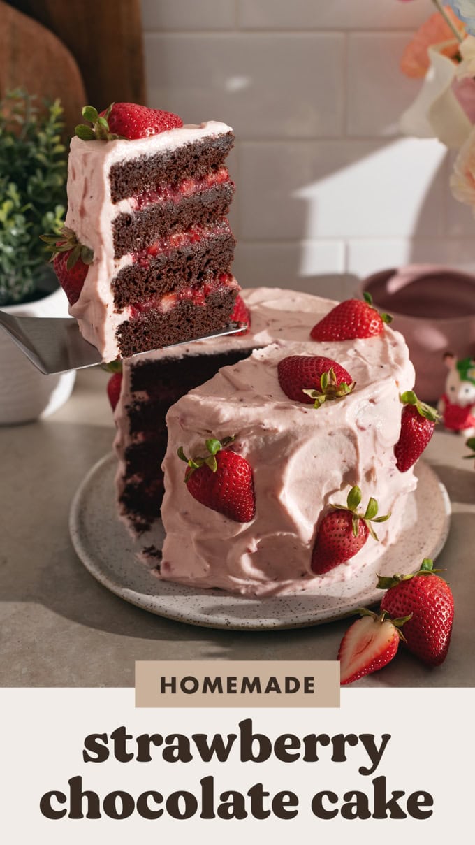 Lifting a slice of strawberry chocolate cake from the rest of the cake with a cake server.