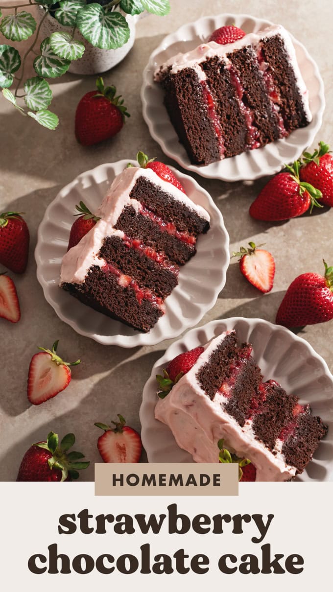 Three slices of chocolate strawberry cake on plates surrounded by strawberries.