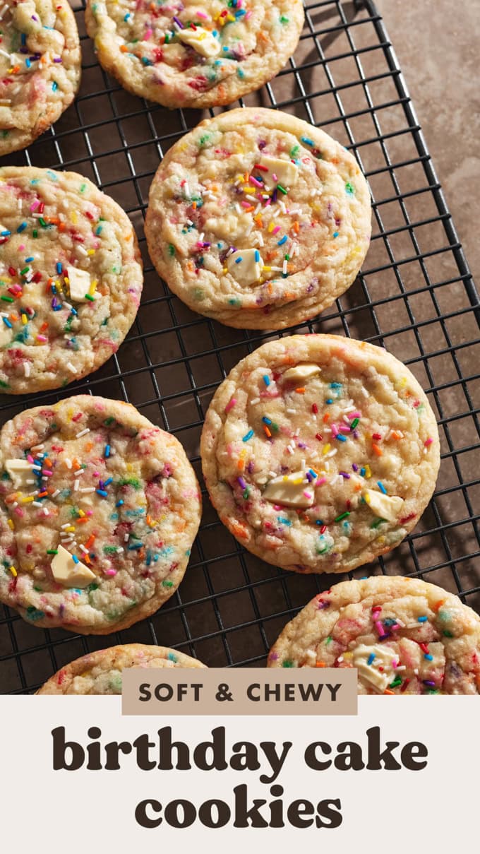 Several birthday cake cookies lined up on a wire rack.