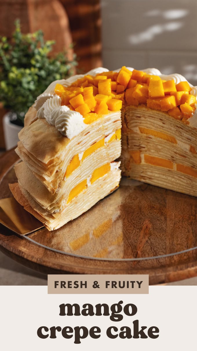 Cross-section of a mango crepe cake showing the layers of crepes, whipped cream, and mangoes inside.